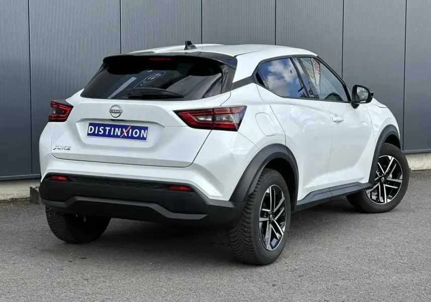 Vue 3/4 arrière droit d'un Nissan Juke blanc nacré avec jantes alliage noires et vitres teintées.