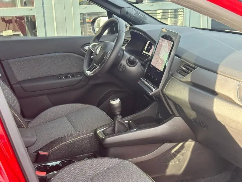 Intérieur côté conducteur du Renault Captur 2025 Rouge Flamme, avec tableau de bord moderne et boîte manuelle visible.
