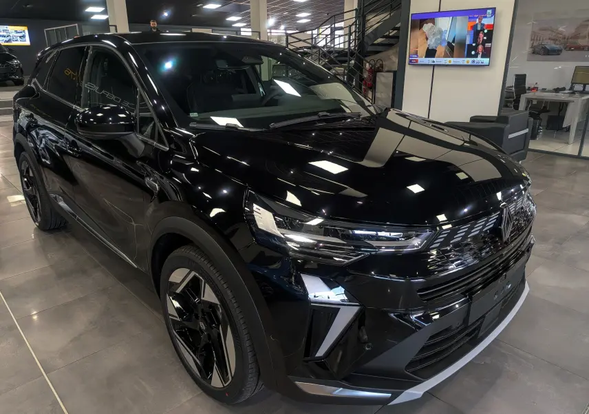 Renault Symbioz E-Tech noir étoilé en 3/4 avant droit, mettant en valeur ses phares LED et jantes biton modernes.