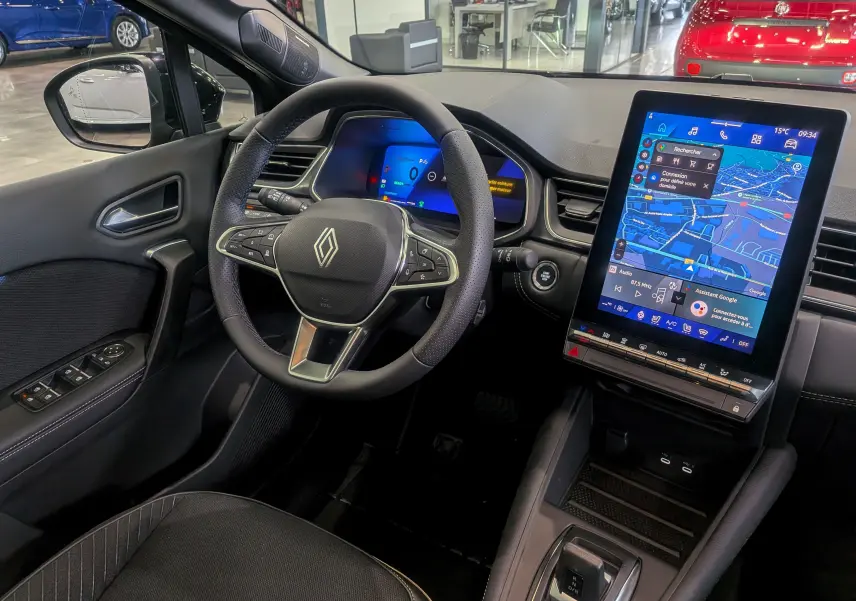 Vue intérieure côté conducteur du Renault SYMBIOZ noir étoilé, avec volant multifonction et grand écran tactile vertical.