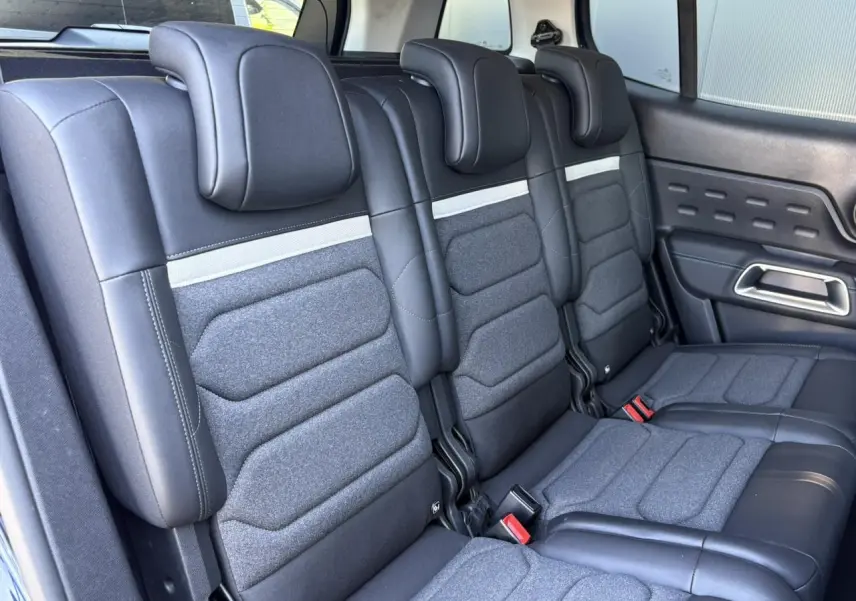 Vue rapprochée des trois sièges arrière indépendants en tissu et cuir noir du Citroën C5 Aircross Hybrid 2025.