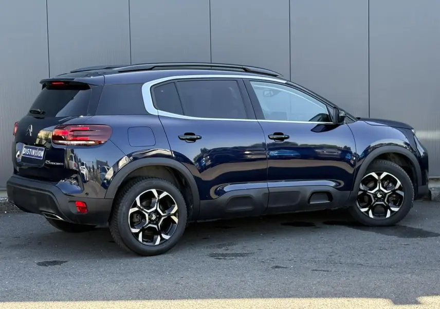 Vue latérale droite d'un Citroën C5 Aircross Hybrid bleu Eclipse avec jantes alliage bi-ton et vitres surteintées.