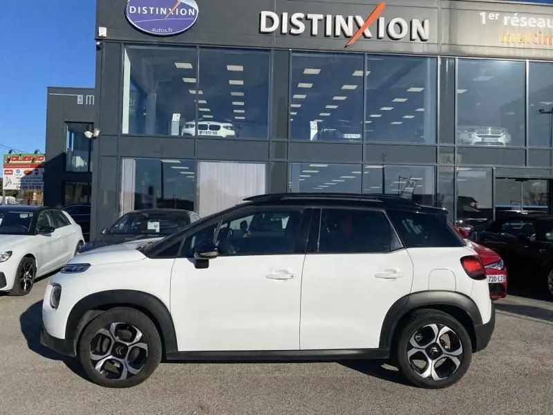 Profil côté gauche d'un Citroën C3 Aircross blanc 2019 avec toit noir et jantes distinctives en concession.