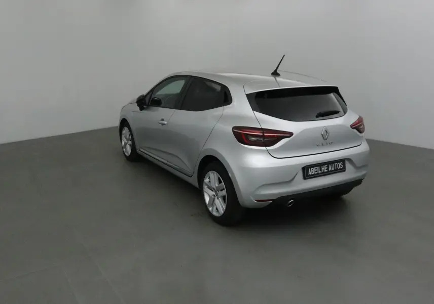 Renault Clio V gris platine vue 3/4 arrière droit dans un studio, avec vitres arrière teintées et jantes alliage.