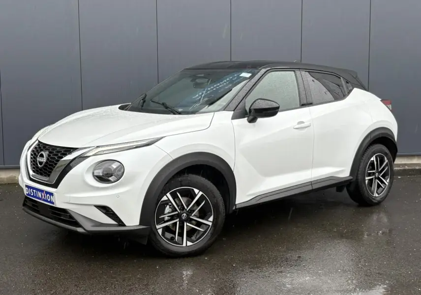 Nissan Juke blanc nacré en 3/4 avant droit, toit noir contrasté et jantes alliage 17 pouces.