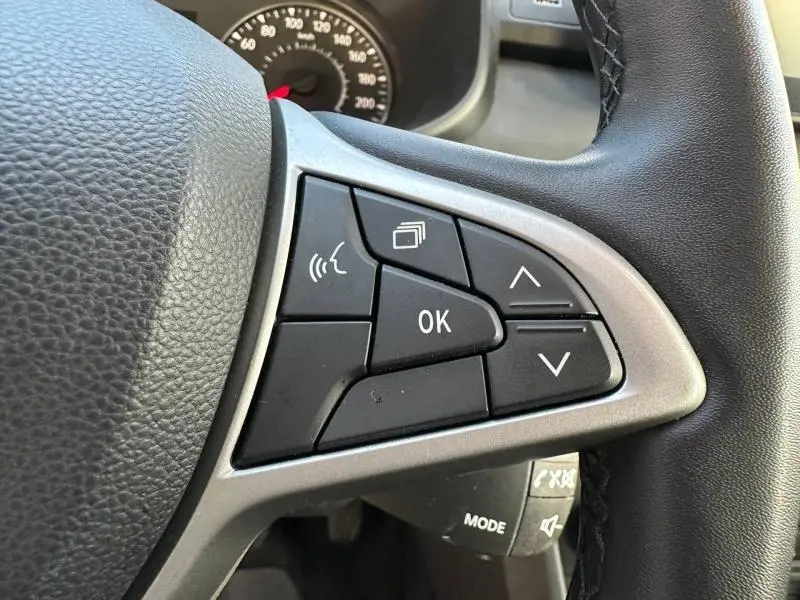 Gros plan sur les commandes multifonctions à droite du volant noir de la Dacia Sandero 2025, finition Stepway Extreme.
