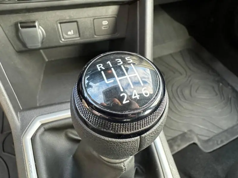 Gros plan sur le levier de vitesses manuel noir de la Dacia Sandero Stepway Extreme 2025, avec indication des six rapports et marche arrière.