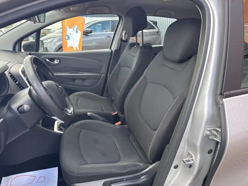 Vue intérieure côté conducteur du Renault Captur gris platine 2019, sièges tissu noir et volant cuir visible.