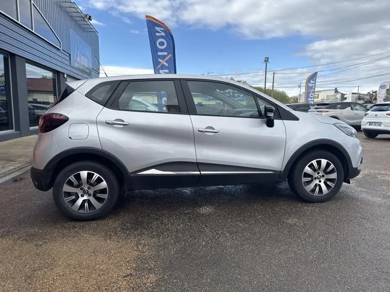 Profil côté gauche d'un Renault Captur gris platine 2019 avec jantes alliage et poignées ton carrosserie.