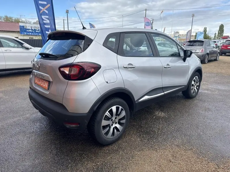 Vue 3/4 arrière droite d'un Renault Captur gris platine 2019 avec jantes alliage et becquet arrière noir.