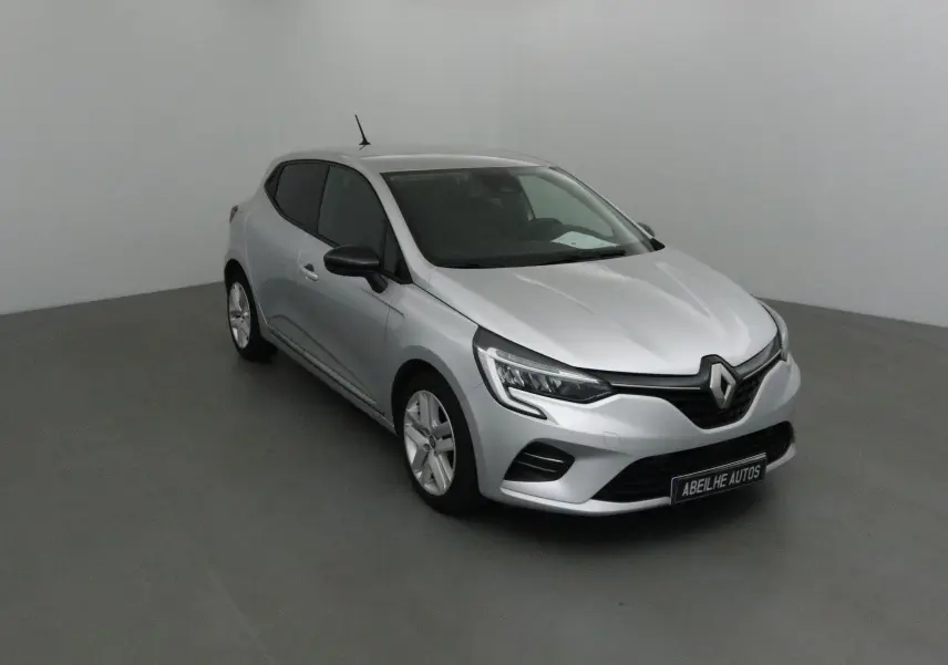 Renault Clio V gris platine vue 3/4 avant droit dans un studio avec phares LED et rétroviseurs noirs.