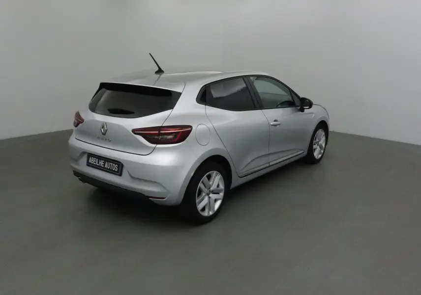 Renault Clio V gris platine vue 3/4 arrière droit dans un studio, avec vitres teintées et jantes alliage.