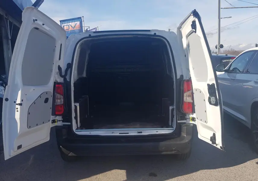 Vue arrière d’un Citroën Berlingo blanc 2025 avec portes arrière ouvertes montrant l’espace de chargement vide.