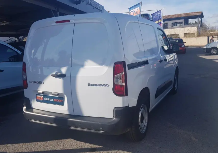 Vue 3/4 arrière droite d’un utilitaire blanc Citroën Berlingo Van 2025 avec porte latérale et jantes acier 15 pouces.