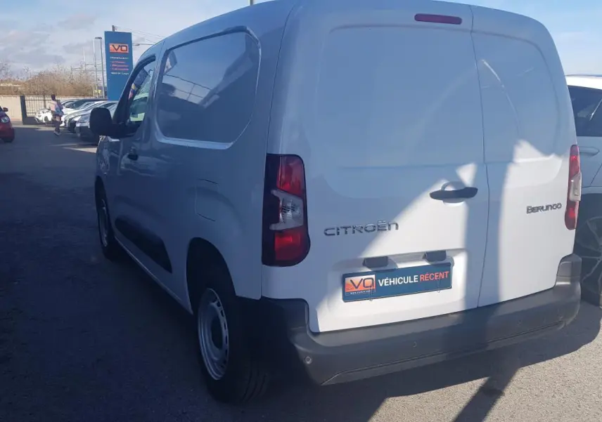 Vue 3/4 arrière droite d’un Citroën Berlingo blanc utilitaire avec porte latérale et jantes acier 15 pouces.