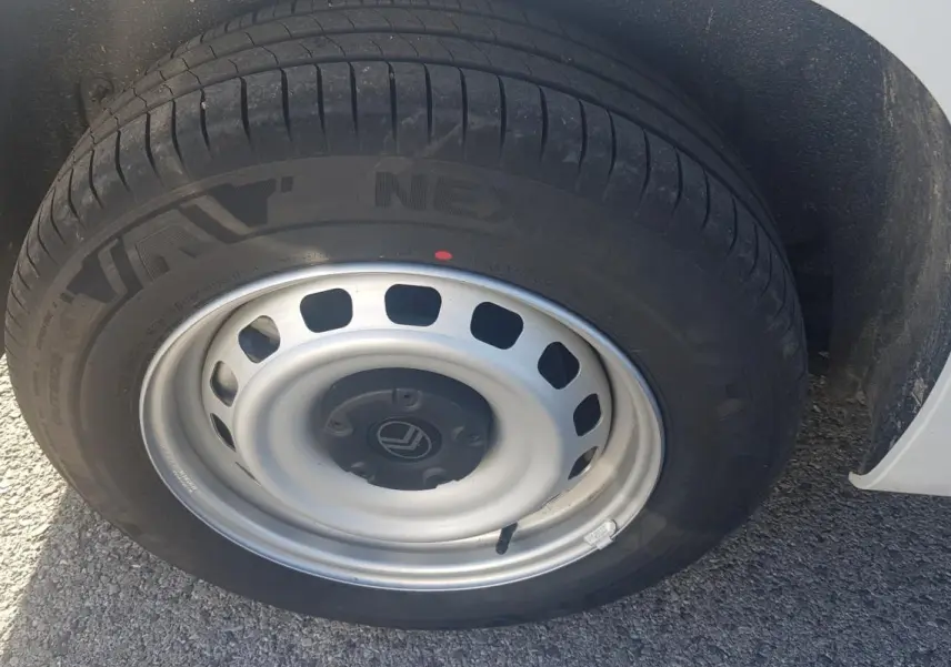 Gros plan sur la roue avant droite blanche d’un Citroën Berlingo 2025 avec jante acier 15 pouces.