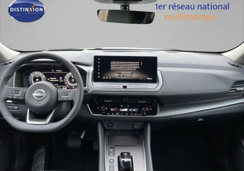 Vue intérieure du tableau de bord du Nissan Qashqai blanc nacré, avec écran tactile central et volant multifonction.