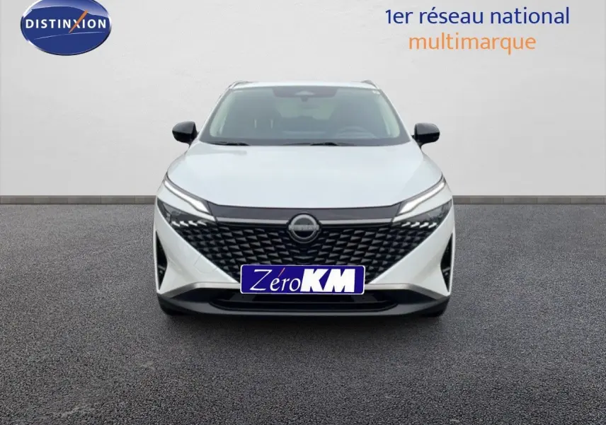 Vue frontale d'un Nissan Qashqai 2025 blanc nacré avec calandre noire et phares LED fins.
