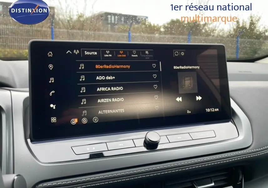 Écran tactile central du Nissan Qashqai blanc nacré 2025 affichant la liste des radios DAB en intérieur.