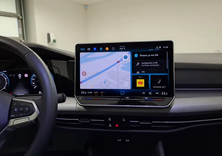 Vue intérieure centrée sur l'écran tactile multimédia et le volant côté gauche de la Volkswagen Golf 1.5 eTSI 116 BVM6 argent Dolomite.