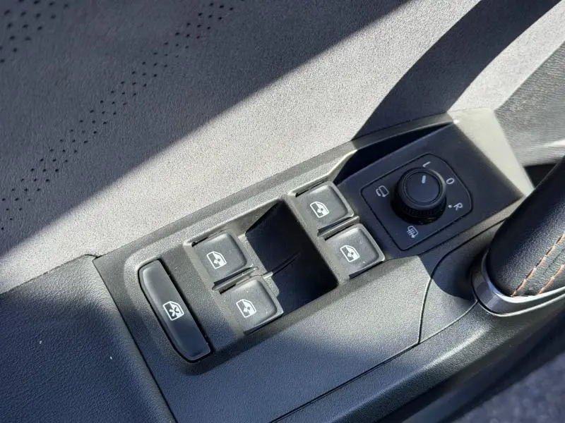Gros plan sur les commandes des vitres et des rétroviseurs côté conducteur du CUPRA Formentor 1.5 eTSI Hybrid noir Minuit 2025.