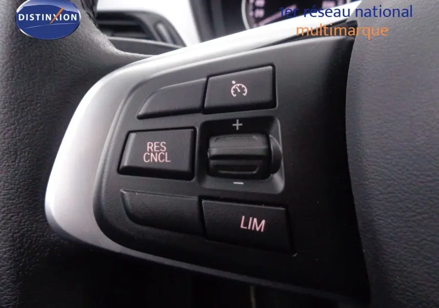 Gros plan sur les commandes de régulateur de vitesse au volant d'un BMW X1 blanc Alpine Metal de 2022.