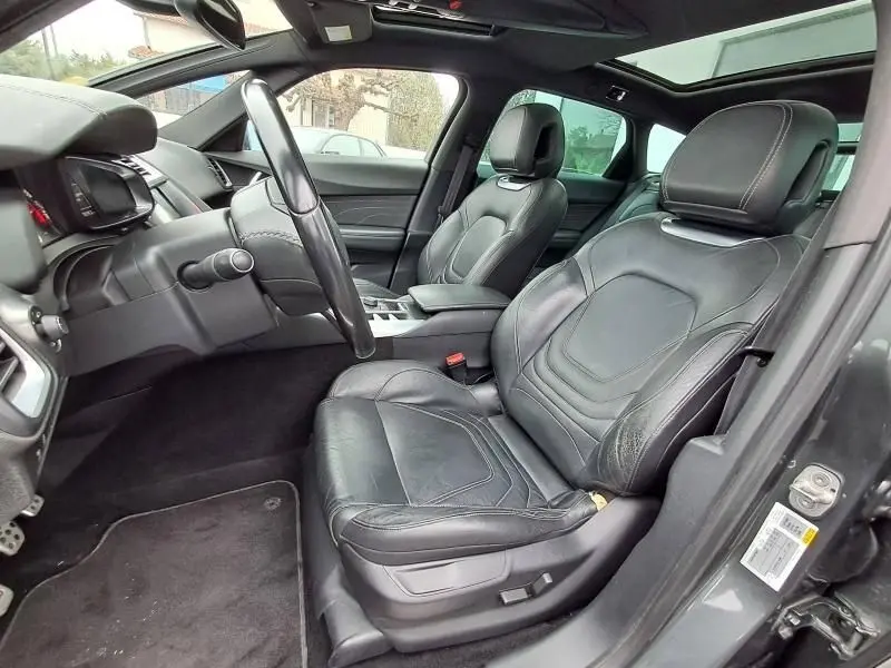 Intérieur de la Citroën DS5 HDI 160 Sport Chic 2014, vue côté conducteur, sièges cuir noirs et toit panoramique.
