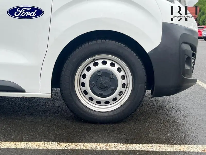 Gros plan sur la roue avant gauche blanche banquise du Peugeot Expert Fourgon 2019 avec enjoliveur acier et logo Peugeot.