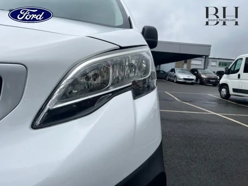 Gros plan sur le phare avant droit blanc Banquise du Peugeot Expert Fourgon 2019 avec porte latérale coulissante visible en arrière-plan.