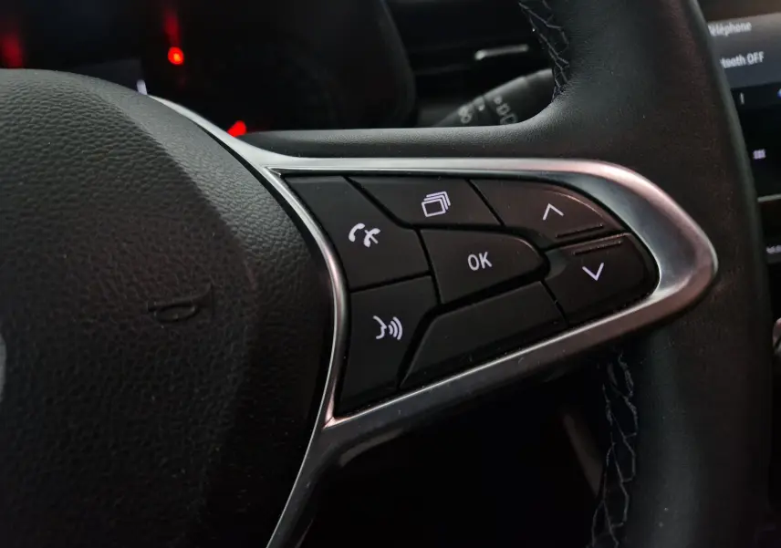 Gros plan sur les commandes multifonctions côté droit du volant noir de la Renault Clio V gris platine 2021.