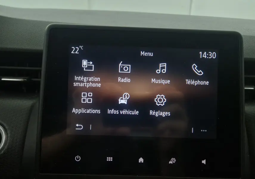 Écran tactile central de la Renault Clio V gris platine affichant le menu multimédia avec options smartphone et radio.