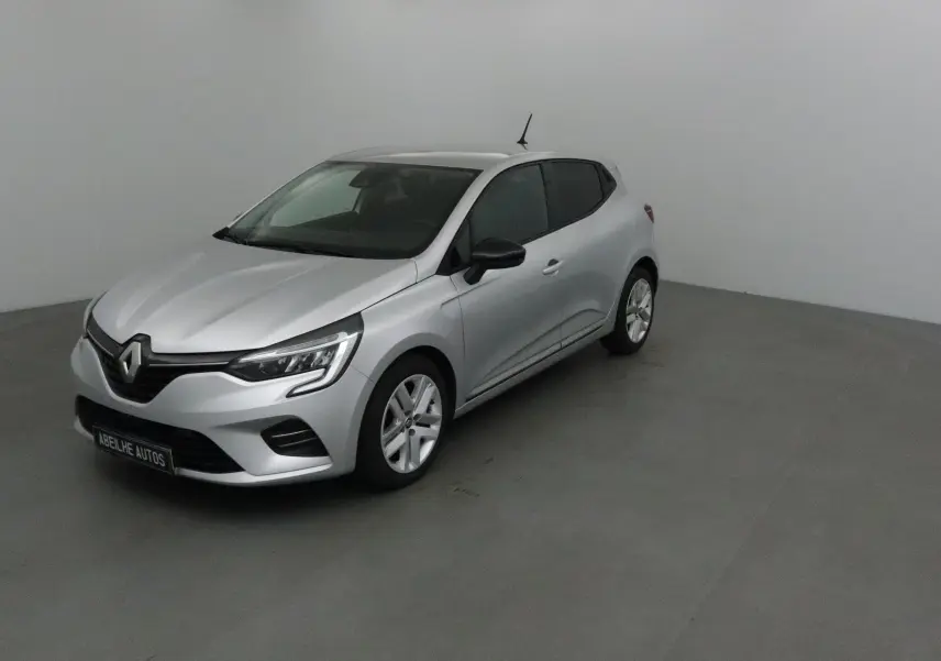 Renault Clio V gris platine vue 3/4 avant droit dans un espace neutre, avec phares LED et jantes alliage.
