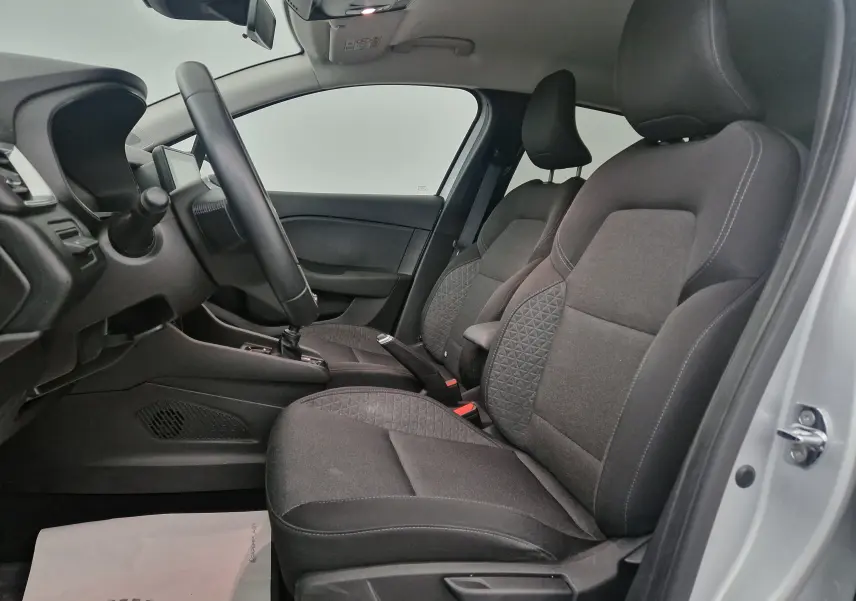 Intérieur côté gauche de la Renault Clio V gris platine, montrant les sièges avant en tissu et le volant.