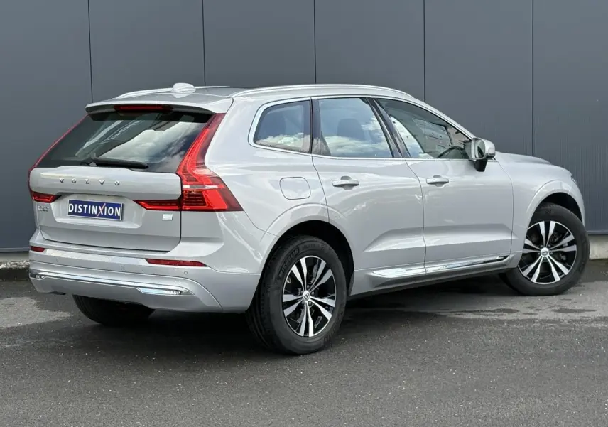 Vue 3/4 arrière droite d'un Volvo XC60 gris silver 2024 avec jantes alliage et vitres teintées.