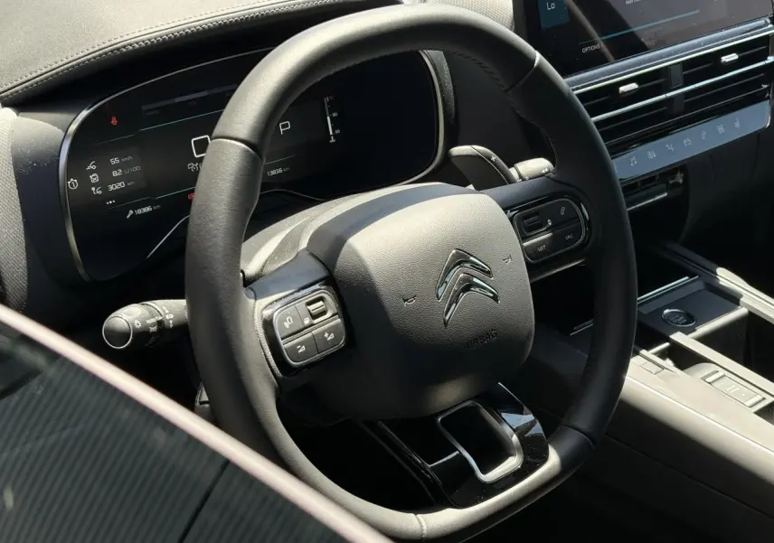 Vue rapprochée du volant cuir noir et du tableau de bord numérique du Citroën C5 Aircross Hybrid 2025.