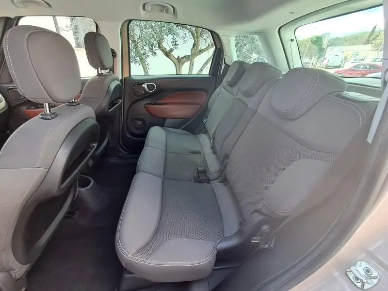 Vue intérieure arrière droite du Fiat 500L beige 2014, montrant les sièges arrière en tissu gris avec détails marron sur les portes.