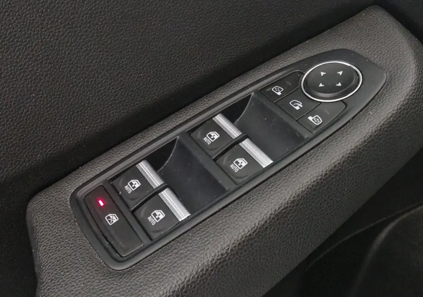 Gros plan sur les commandes de lève-vitres et rétroviseurs côté conducteur d'une Renault Clio V 1.0 TCE 90 Zen 2021.