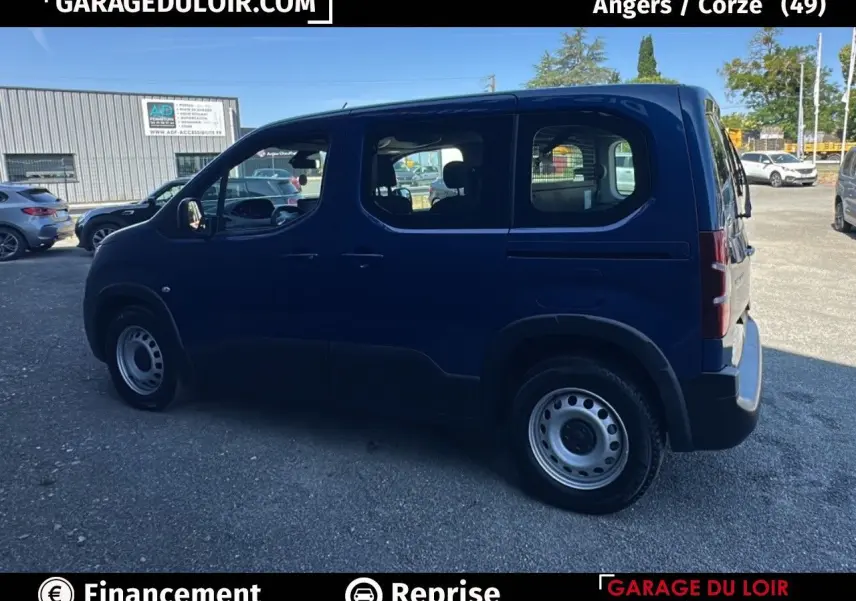 Profil côté gauche d'un Peugeot Rifter bleu 2024 avec porte coulissante et jantes tôles en extérieur.