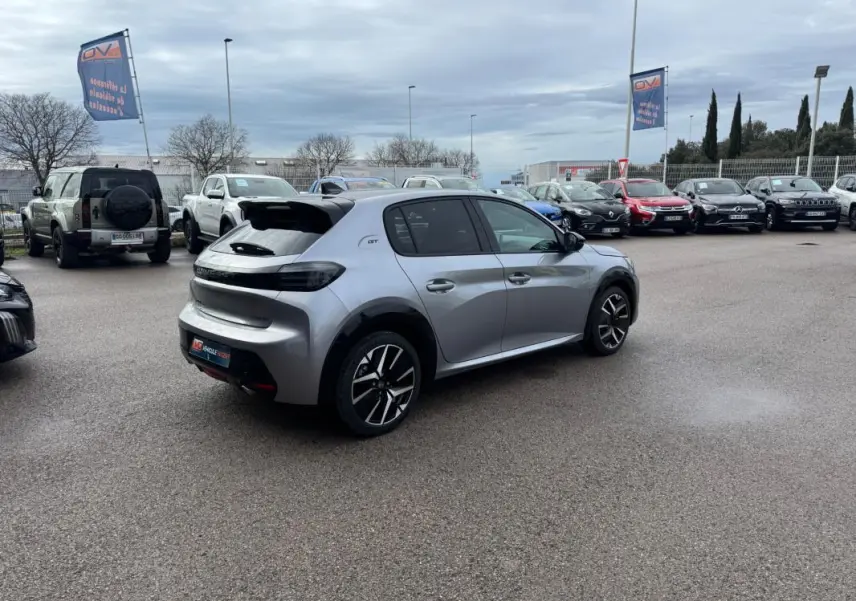 PEUGEOT 208 Hybrid 110 e-DCS6 GT gris vu en 3/4 arrière droit, avec jantes alliage 17 pouces et feux arrière noirs.