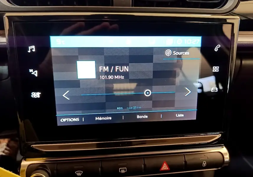 Écran tactile central de la Citroën C3 2022 affichant la radio FM avec commandes tactiles et boutons de climatisation en dessous.