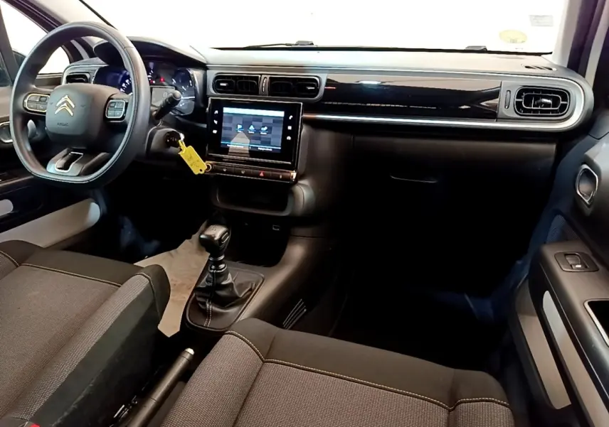 Intérieur noir de la Citroën C3 2022, vue de face côté conducteur avec tableau de bord et écran tactile central.