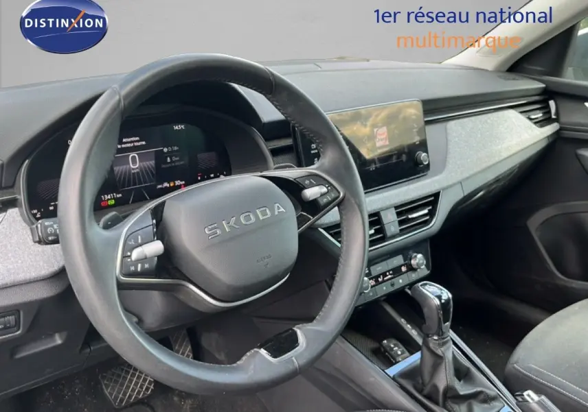 Intérieur de la Skoda Scala 2025 en gris, vue côté conducteur sur le volant, tableau de bord et console centrale.