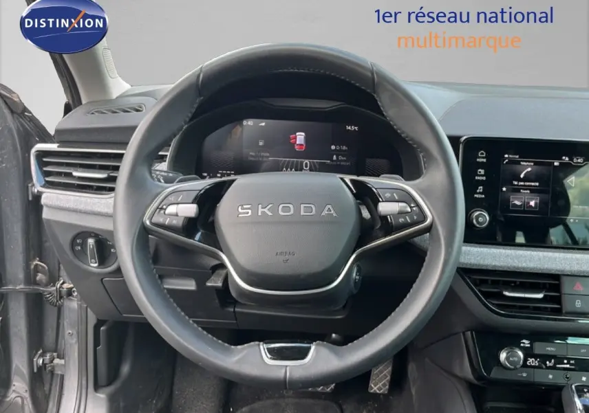 Vue intérieure centrée sur le volant cuir de la Skoda Scala gris magnétique, avec tableau de bord digital et écran tactile.