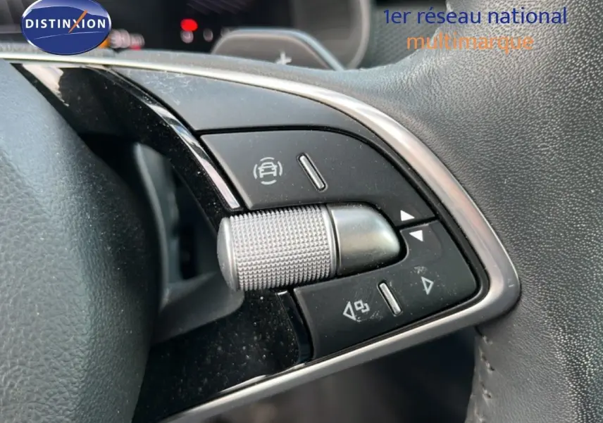 Gros plan sur les commandes multifonctions en aluminium brossé du volant cuir gris noir d'une Skoda Scala gris magnétique.