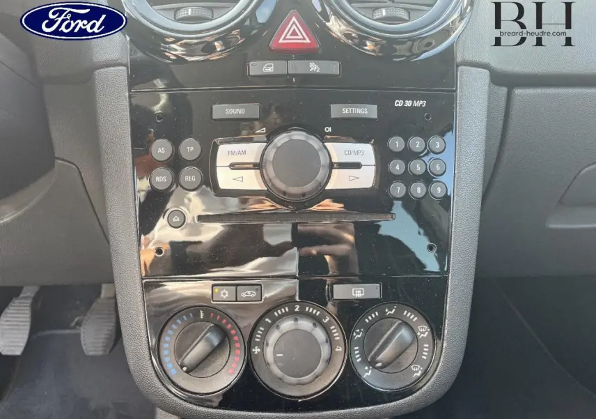 Console centrale noire de l’Opel Corsa 1.2 Twinport GPL Essentia 2010 avec commandes radio et climatisation manuelle.