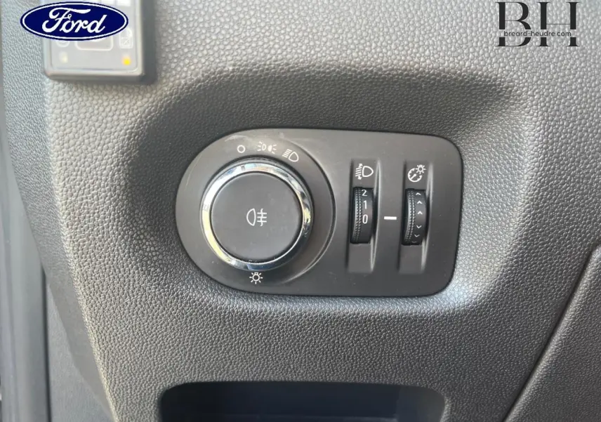 Gros plan sur les commandes d’éclairage intérieures d’une Opel Corsa noire, bouton rotatif et réglages lumineux visibles.