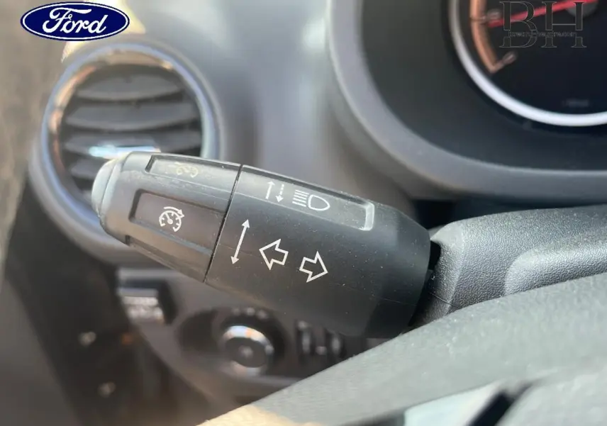 Gros plan sur la commande de clignotants et feux d’une Opel Corsa noire, vue côté conducteur intérieur.