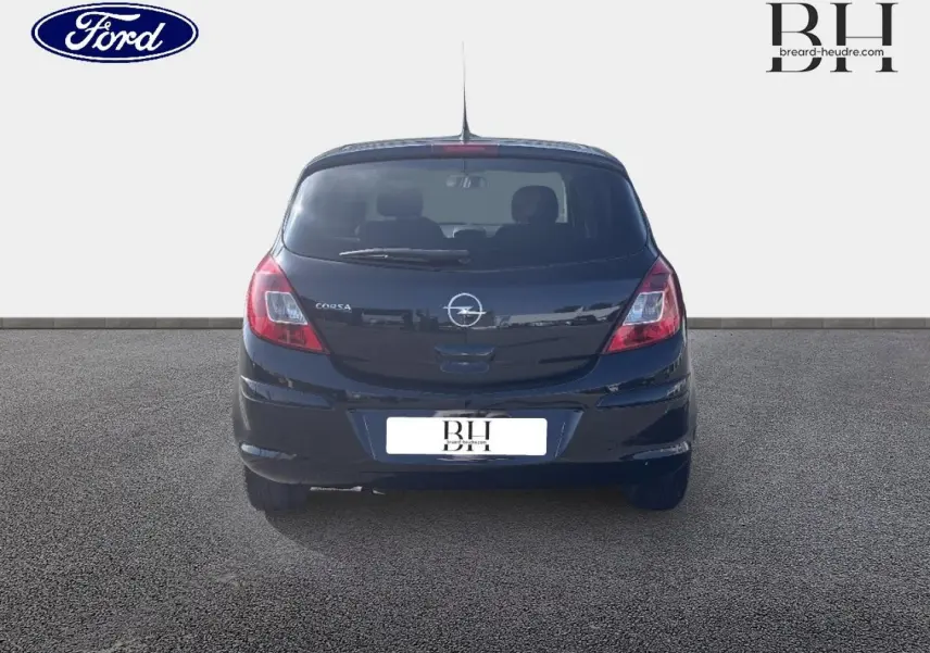 Vue arrière d'une Opel Corsa noire de 2010, compacte avec feux arrière rouges et lunette arrière avec essuie-glace.