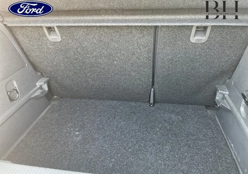 Coffre vide de l’Opel Corsa 1.2 Twinport GPL noir, vue intérieure arrière avec revêtement gris.