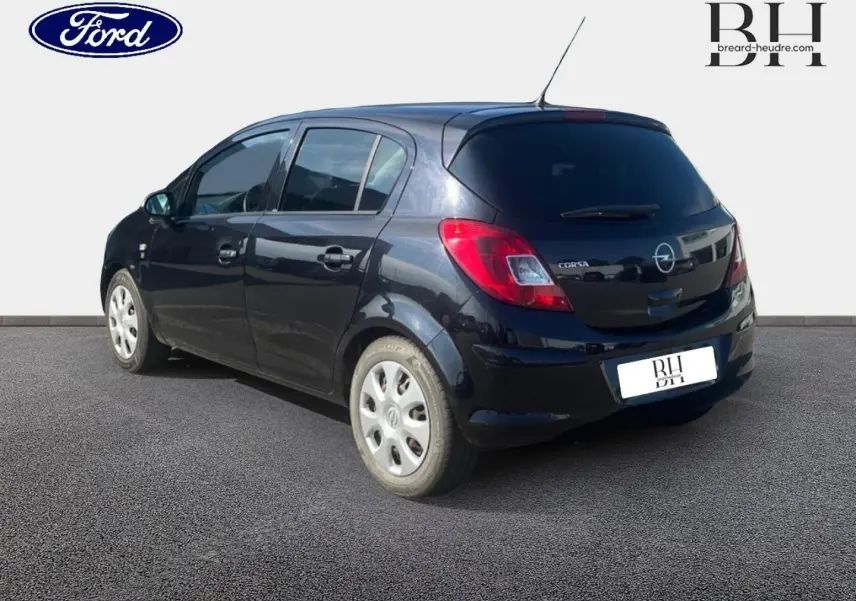 Vue 3/4 arrière droite d'une Opel Corsa noire de 2010, compacte avec feux arrière rouges et jantes argentées.
